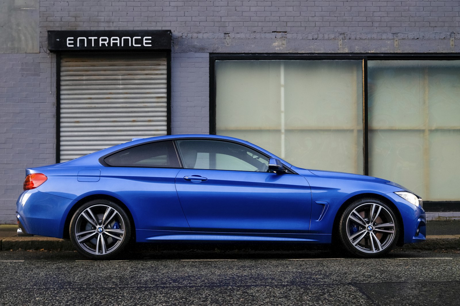 A blue rental car parked in front of a service entrance